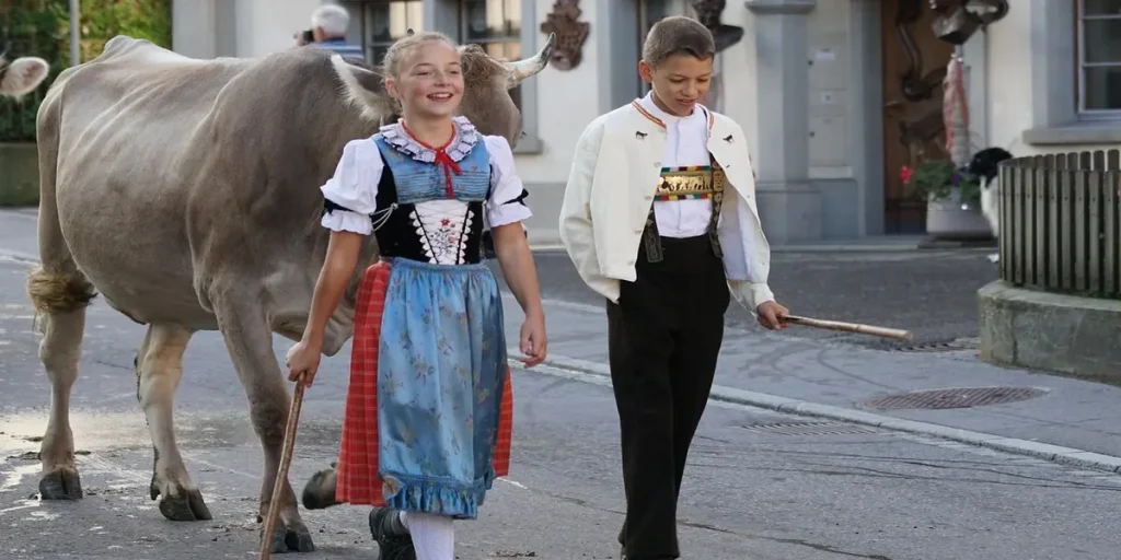 Dos personas caminando por una calle suiza con arquitectura tradicional, reflejando la vida cotidiana y la cultura local