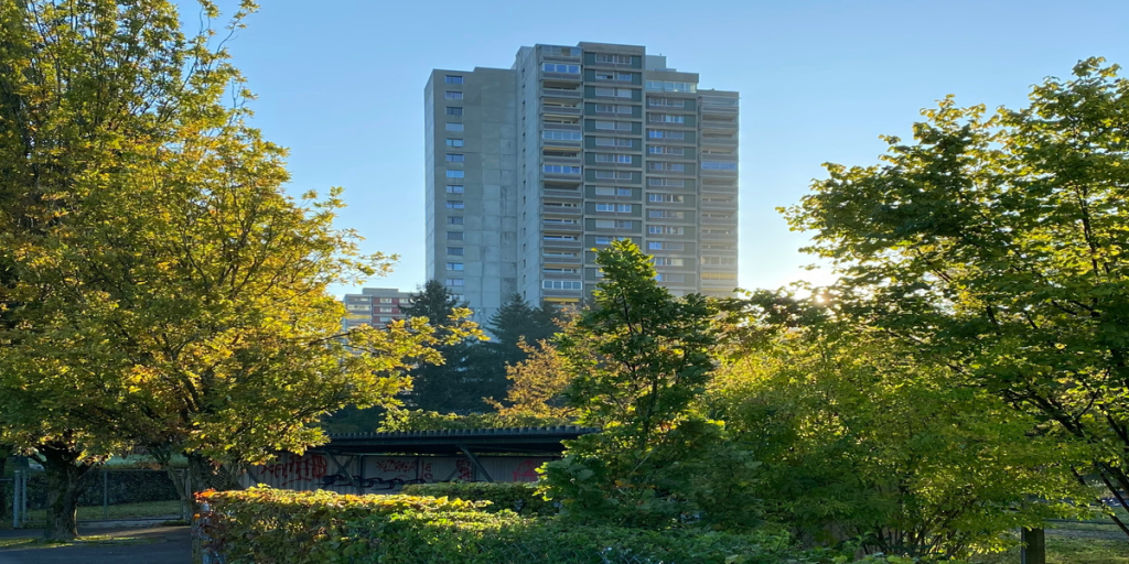 Edificio residencial en Suiza rodeado de árboles y cielo despejado