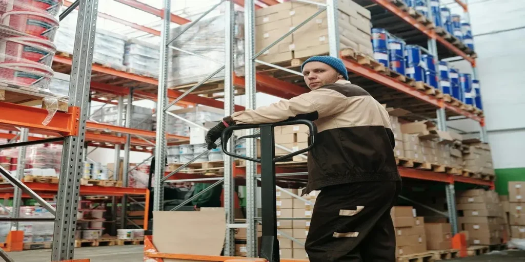 Trabajador con casco operando una carretilla elevadora en un centro de logística en Suiza, un sector con alta demanda de empleo.