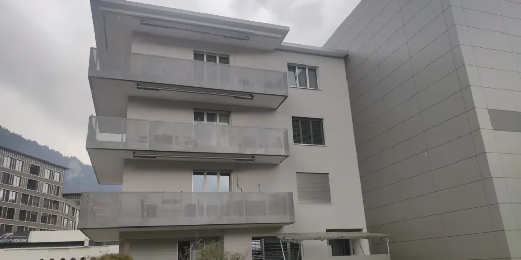 Fachada de edificio de viviendas con balcones en Suiza en un día nublado
