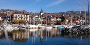 Puerto en la Riviera de Vaud con barcos y casas junto al lago Lemán